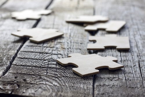 Image of puzzle pieces on wooden table