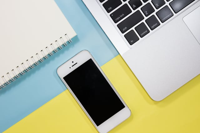 arrangement of notebook, iphone and macbook on a table